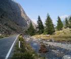 Río en el valle junto a una estrecha carretera de montaña