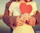 Una pareja enamorada con un corazón rojo en sus manos
