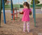 Una niña jugando en el parque con el columpio