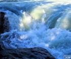Imagen de un rápido de río, provocado por un aumento en la velocidad y la turbulencia del agua