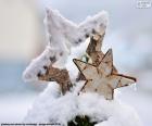Dos estrellas Navideñas de madera parcialmente cubiertas por la nieve