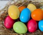 Huevos de Pascua pintados en varios colores colocados dentro de un nido