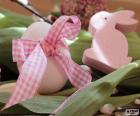 Un huevo con un lazo y un conejo de color rosa para celebrar la Pascua