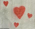 Cuatro corazones rojos pintados en una fachada