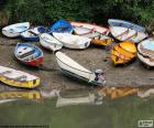 Varios botes estacionados en la orilla de un lago