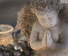 Un ángel de Navidad junto a una vela y varias bolas navideñas