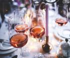 Varias copas de vino rosado encima de la mesa