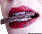 Mujer comiendo un trozo de chocolate