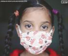 Una niña protegida con una mascarilla, la solución para ayudar a detener la propagación del COVID-19 y evitar la transmitírselo a los demás