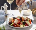 Una deliciosa ensalada griega, con tomate, pepino, cebolla, aceitunas negras y queso feta. Un plato de la dieta mediterránea saludable y muy fácil de preparar.
