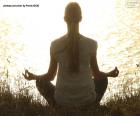 Mujer en plena meditando frente a un lago